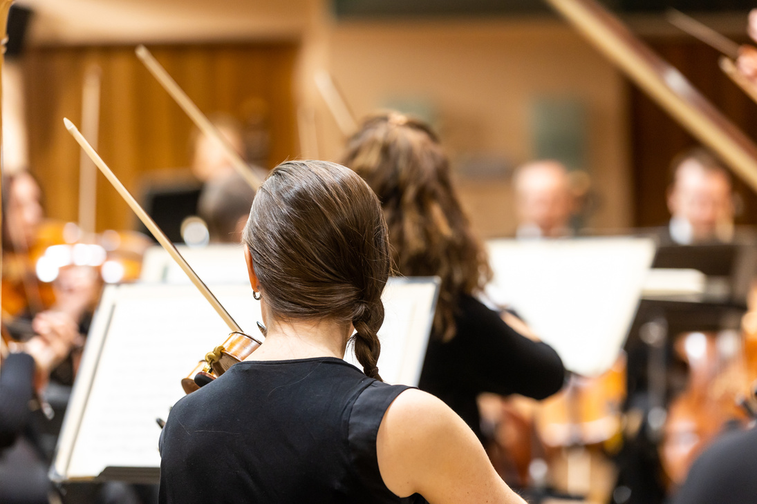 Professional symphonic string orchestra performing on stage and
